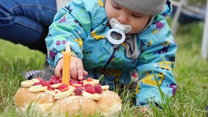 Little boy tries to take cake on his first birthday in the park in slowmotion. 1920x1080