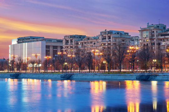 Bucharest Sunset. Unirii Boulevard Night Lights Reflection on Dambovita river.
