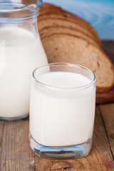 Bread slices, milk on a wooden table and blue wooden background