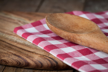 wood cutting board, spoon, napkin on wooden background