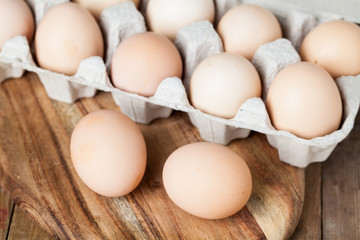 fresh eggs in container on wood background