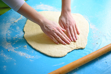 Hands baking dough on table