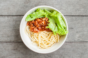 Spaghetti in bowl on wooden table