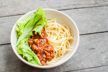 Spaghetti in bowl on wooden table