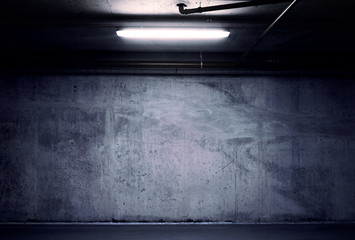Urban underground background. Concrete wall under the lamp light in the dark