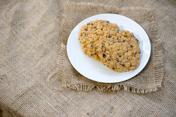 chocolate chip cookie on white dish burlap