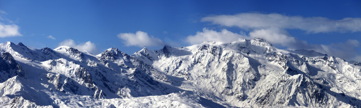 Panoramic view on snowy mountains in nice sunny day