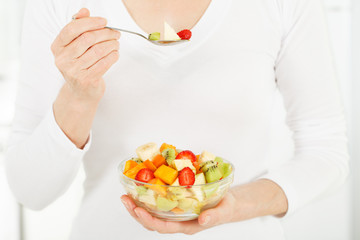 Fruit salad in the hands of women.