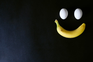 Eggs and banana on black background, close up