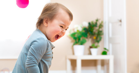 Happy toddler girl smiling in her house