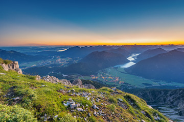 view from top of mountain to valley with lake plansee at sunrise