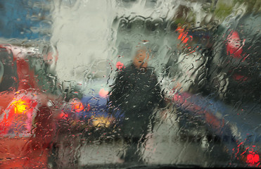 Abstract urban view through the wet car windscreen under the rain. 