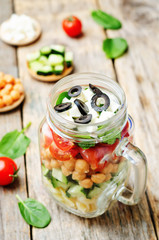 Pasta chickpeas cucumber tomatoes spinach goat cheese salad in a