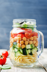 Pasta chickpeas cucumber tomatoes spinach goat cheese salad in a