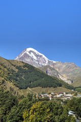 Fototapeta na wymiar View of Mount Kazbek and Holy Trinity Church (Tsminda Sameba) near Gergeti village, Georgia