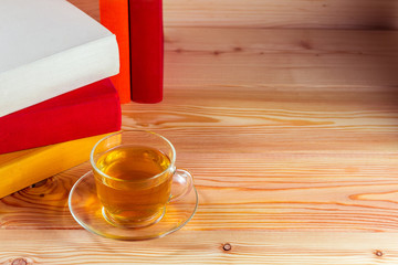 Cup of tea and books onwooden background
