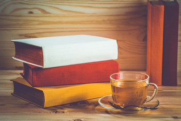 Cup of tea and books onwooden background