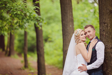 Young wedding couple enjoying romantic moments outside on a summer meadow