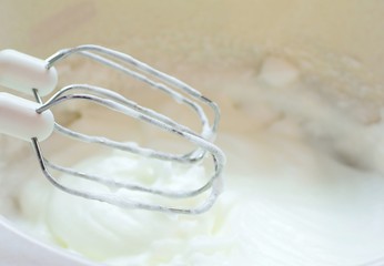 Whisk with egg white mixing into snow.