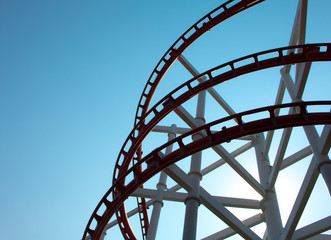 Theme Park Rollercoaster against blue sky .