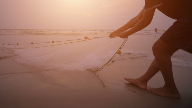 Fishermen pull net from the ocean