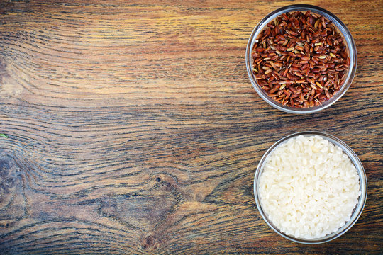 White and Red Rice in Glass Cup on Wooden Background