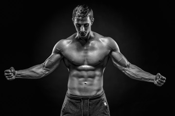 Obraz na płótnie Canvas Stunning muscular man showing perfect abs, shoulders, biceps, tr