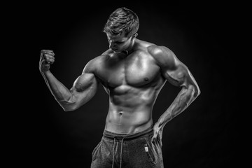 Fototapeta na wymiar Stunning muscular man showing perfect abs, shoulders, biceps, tr