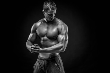 Fototapeta na wymiar Stunning muscular man showing perfect shoulders, biceps, triceps