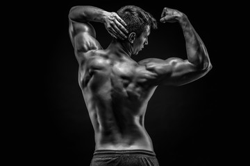 Fototapeta na wymiar Healthy muscular young man showing back and biceps muscles