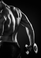 Muscular fitness man with dumbbells, rear view. Close-up