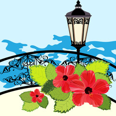 Tropical coastline with lantern, fence and flowers