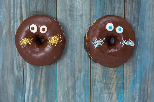 Hand Decorated Artisan Donuts On Wooden Rustic Table, From Above