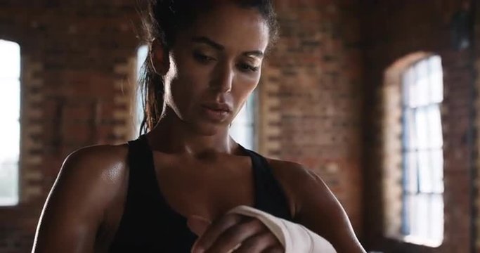 Kickboxing woman putting on punching wraps in fitness studio