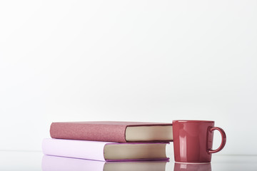 Books with a coffeecup. On white background with copy space.