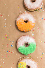 Sweet sugary donuts on crumpled baking paper, top view of tasty