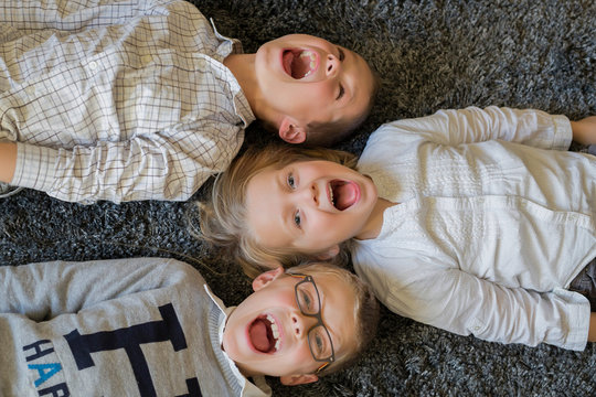 High angle view of brothers an sister playing on the floor