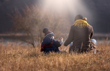 Happy caucasian child playing outdoor - walking with his mother