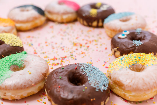 Assorted donuts on a pastel pink background, copyspace