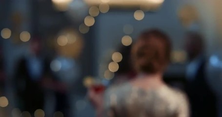 Elegant woman dressed in gold holding cocktail