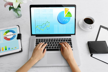 Woman working with modern laptop, with scheme on screen