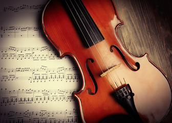 Fototapeta premium Violin and musical notes on wooden background