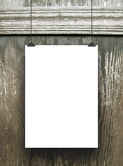 Close-up of one hanged paper sheet with clips on wooden background