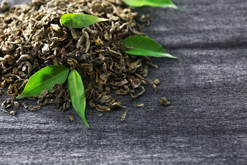 Granulated tea with green leaves on grey background