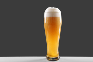 Glass of lager beer on grey background