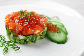 Delicious salmon tartare with red caviar on white plate