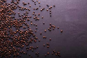 Roasted coffee beans on grey textile background