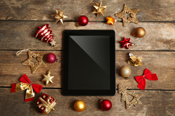Tablet and Christmas decor on wooden background