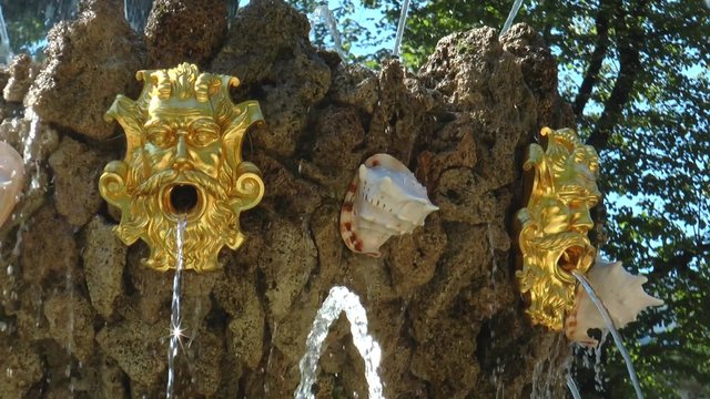 Элементы оформления большого фонтана в Летнем саду Санкт-Петербурга, Россия, в виде двух золотых масок, изо рта которых бьёт струи воды.