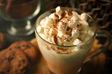 Cup of hot cacao with marshmallow and cookies on black table